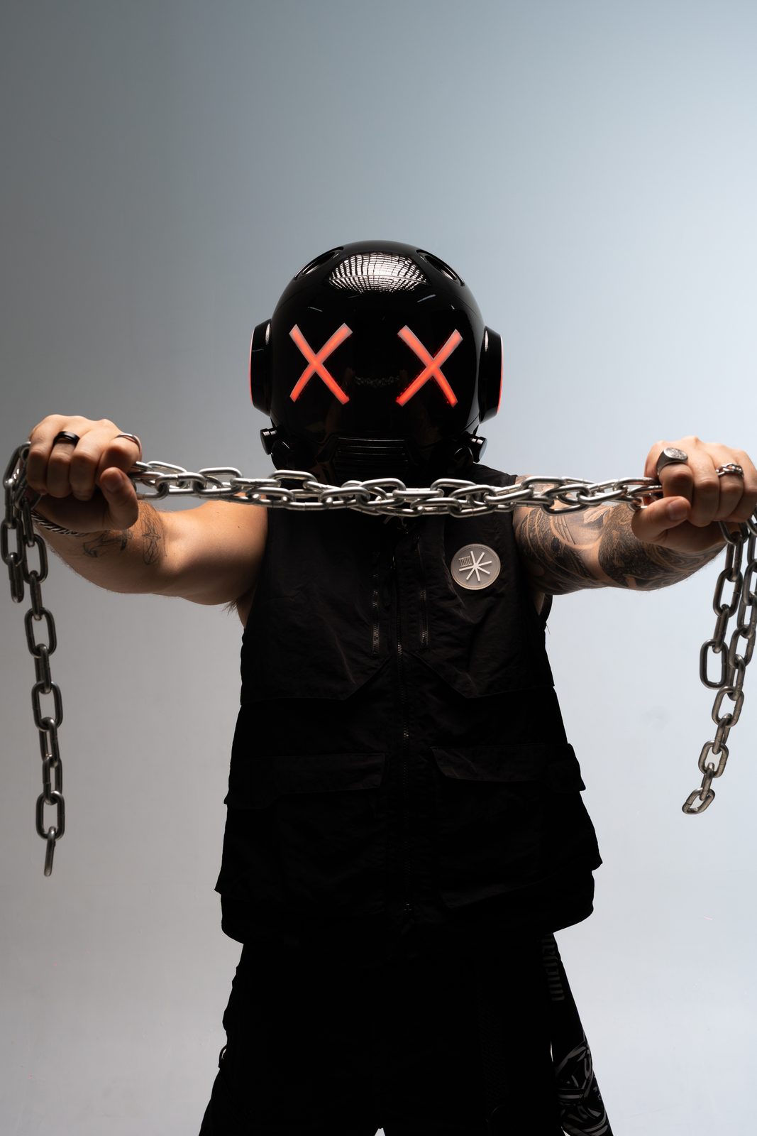 Masked DJ pulling a chain taut