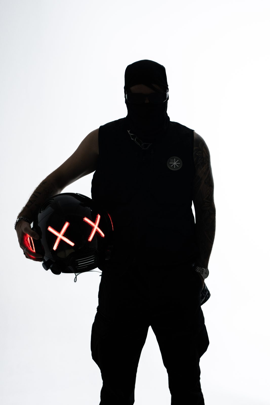 Silhouetted figure holding a glowing helmet