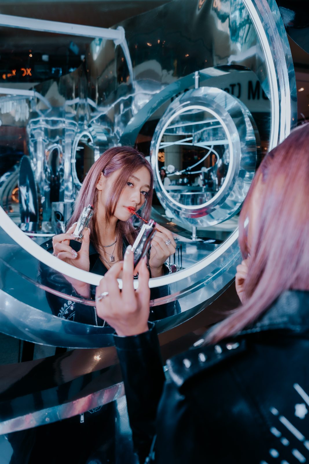 Guests framed in a curved chrome mirror