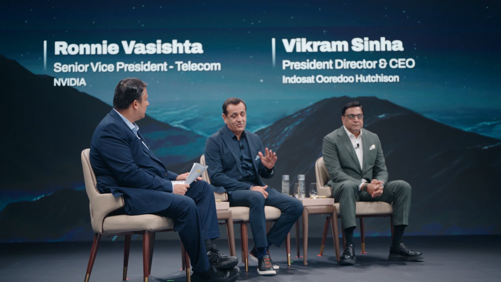Three executives on stage during a telecom panel at Aether Summit